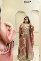 Woman in a pink Indian outfit with mirror work in a fitting room