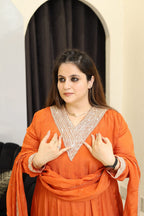 Woman in an orange kurti with intricate neckline embroidery