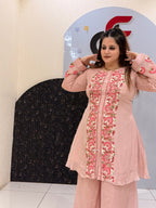 Woman wearing a pink floral embroidered co-ord set with bell sleeves
