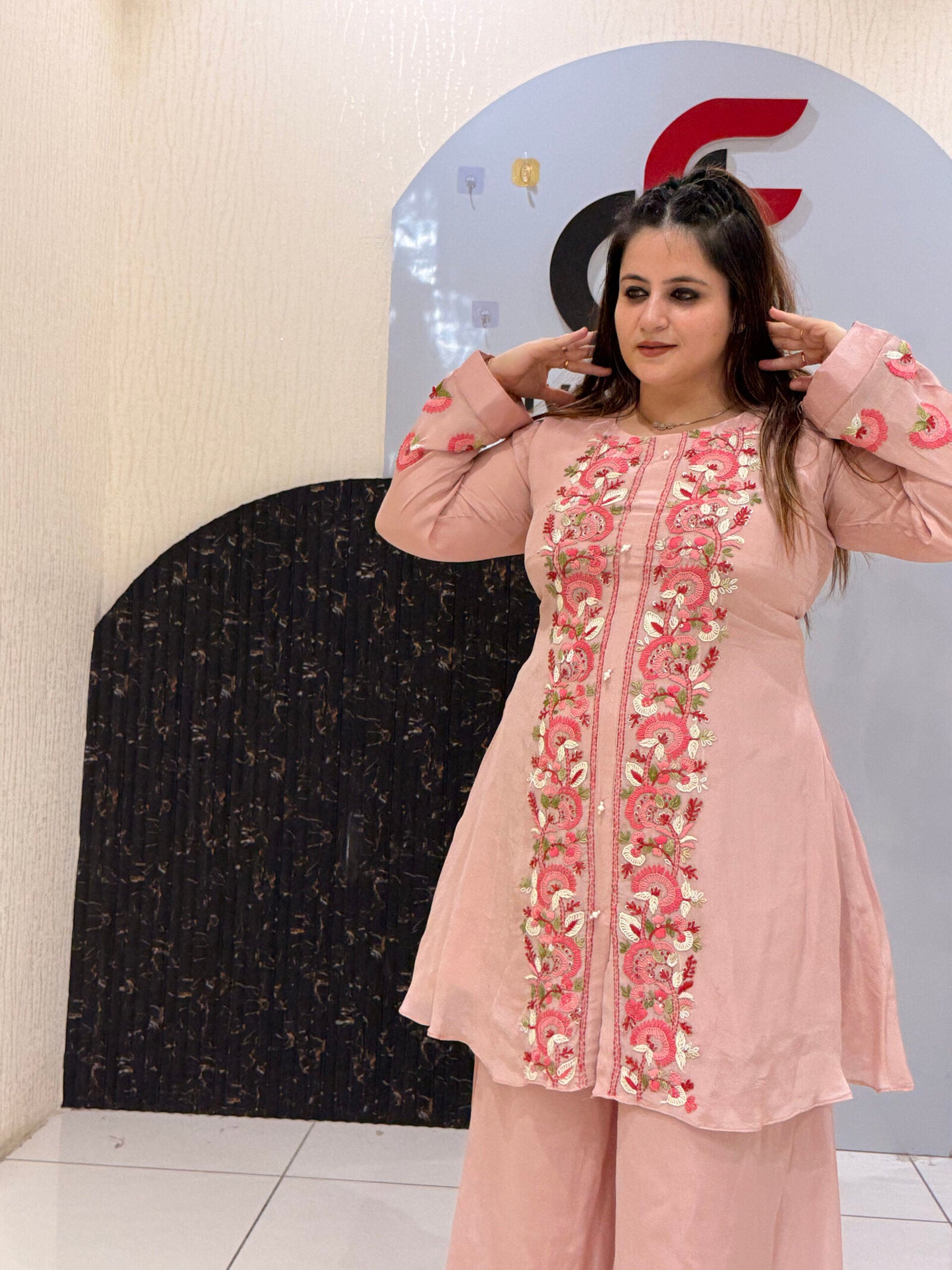 Woman wearing a pink floral embroidered co-ord set with bell sleeves