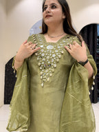 Woman in a green, embellished kaftan with shell details