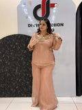 Woman in peach floral embroidered button-down co-ord set with wide-leg pants.