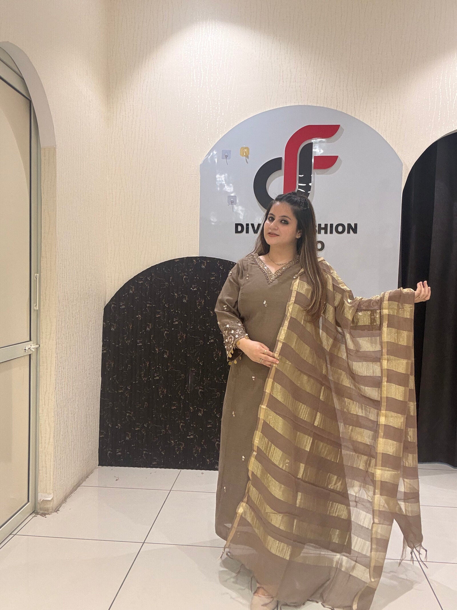 Sophisticated brown Mul suit featuring delicate embroidery and a golden striped dupatta