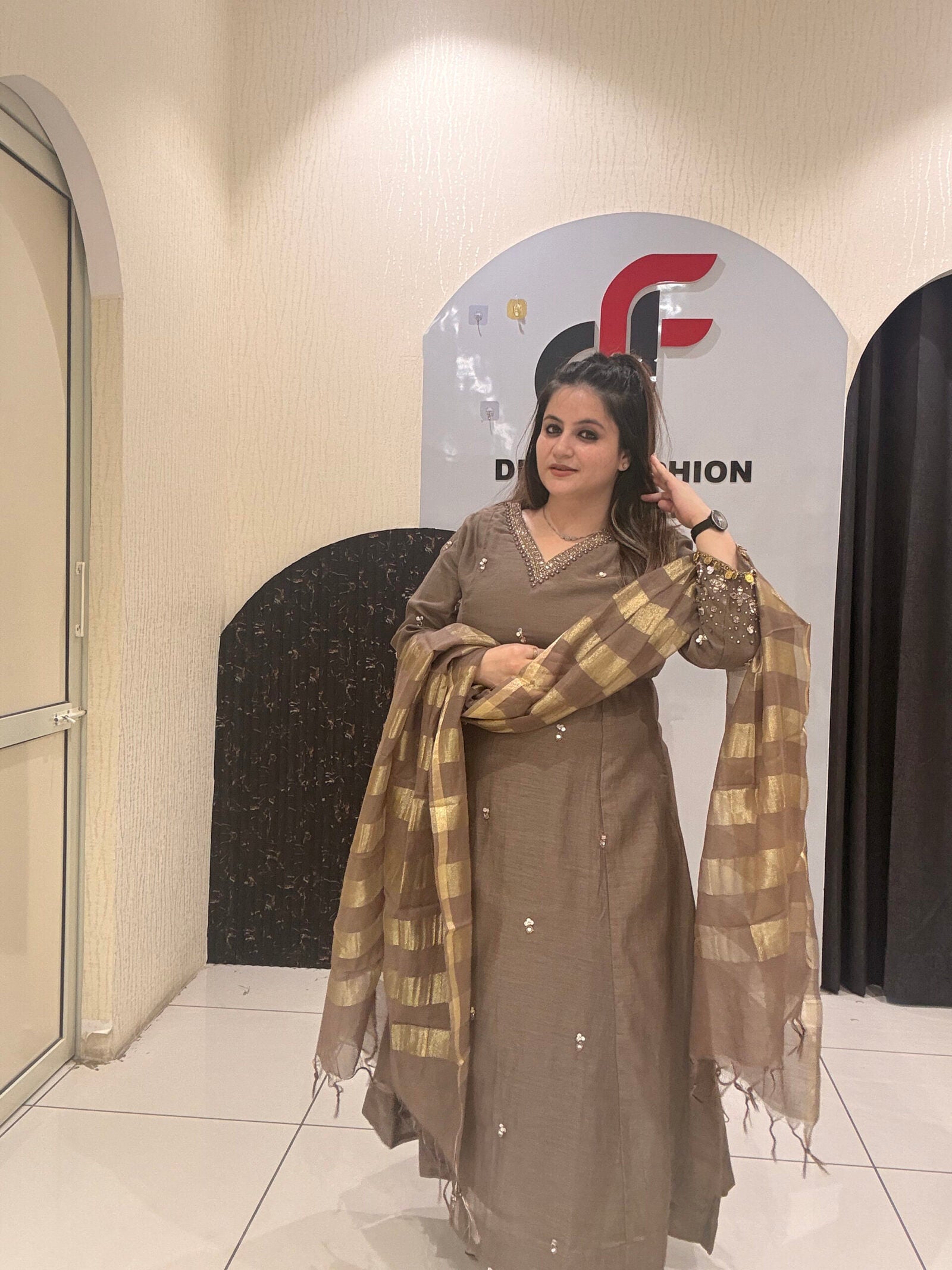 Sophisticated brown Mul suit featuring delicate embroidery and a golden striped dupatta