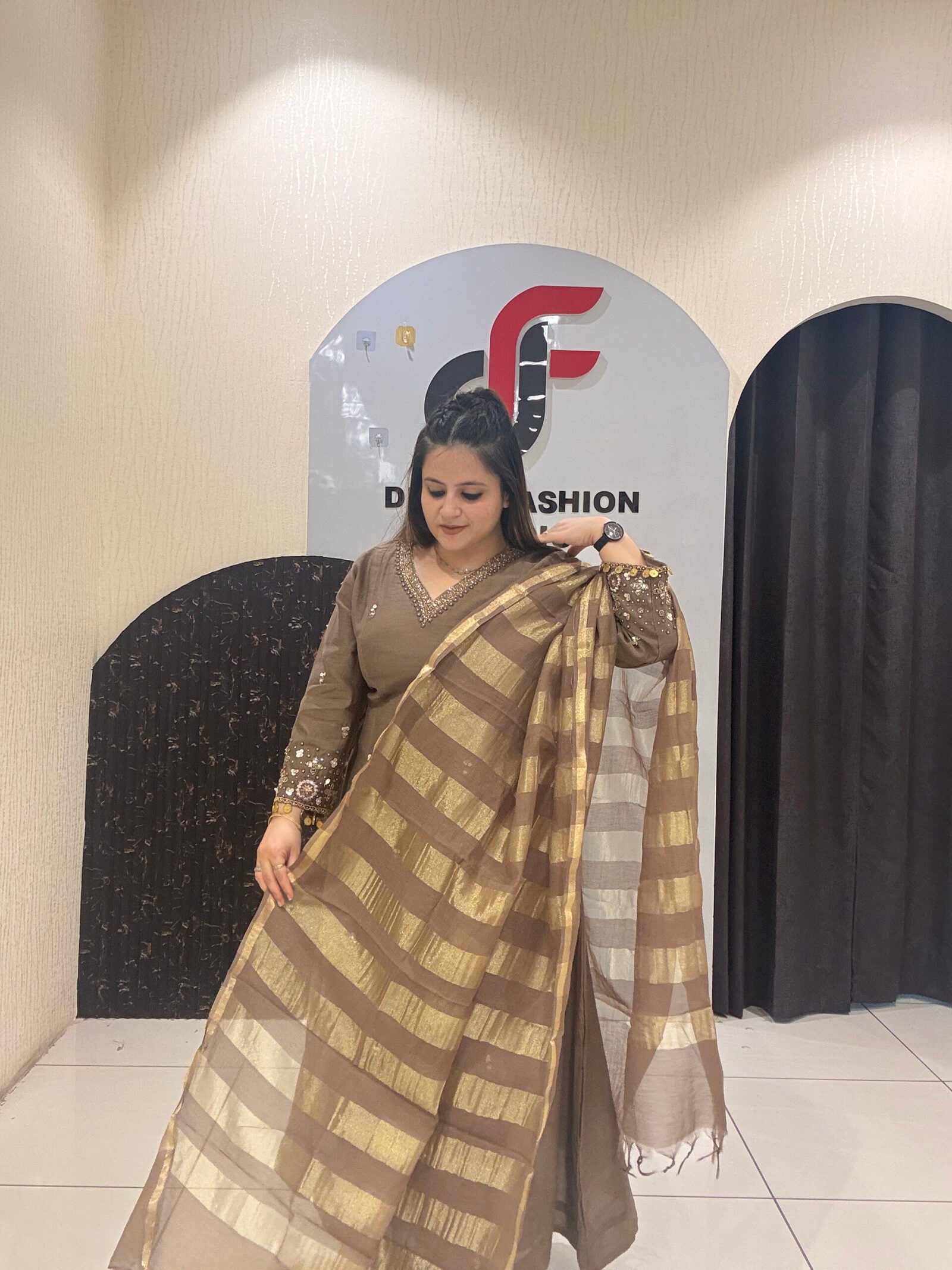 Sophisticated brown Mul suit featuring delicate embroidery and a golden striped dupatta