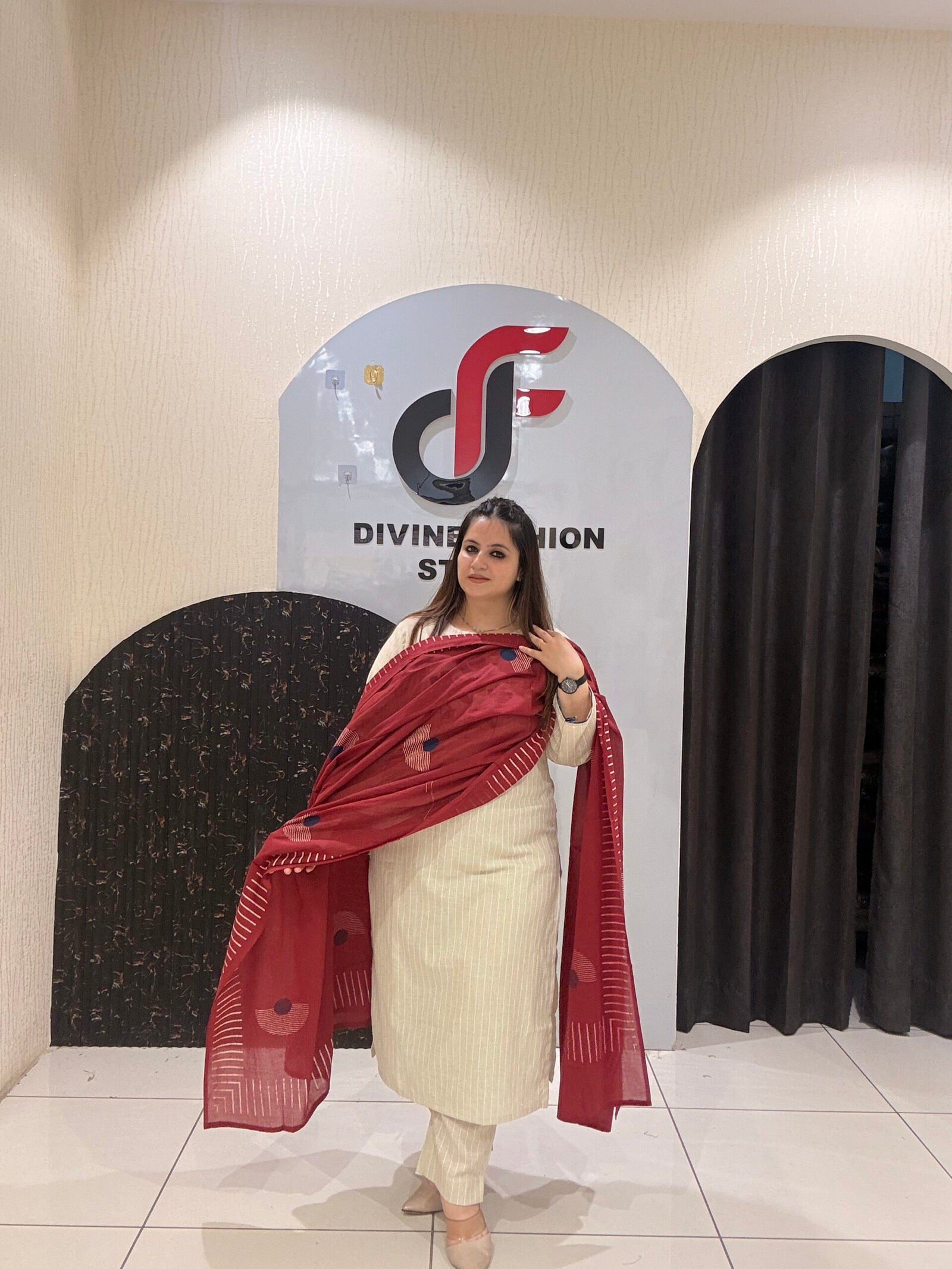 Elegant cream cotton suit featuring floral embroidery in red and blue tones, paired with a contrasting red dupatta.