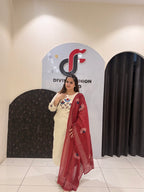 Elegant cream cotton suit featuring floral embroidery in red and blue tones, paired with a contrasting red dupatta.