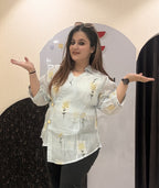 Stylish cotton tops featuring delicate yellow floral embroidery and sheer sleeves.