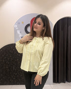 Chic pastel yellow color top featuring lace detailing and a tie-neck design