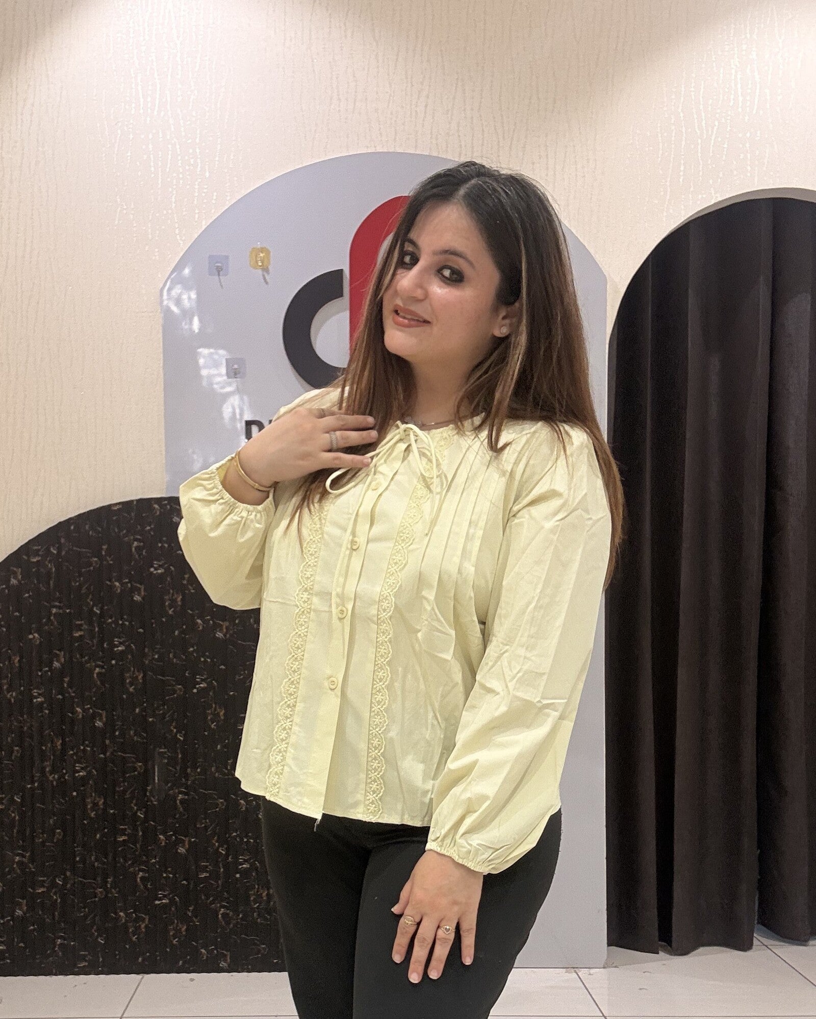 Chic pastel yellow color top featuring lace detailing and a tie-neck design