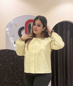 Chic pastel yellow color top featuring lace detailing and a tie-neck design