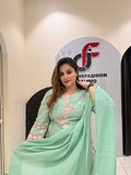 Graceful mint green cotton suit featuring intricate floral embroidery and tassel detailing.
