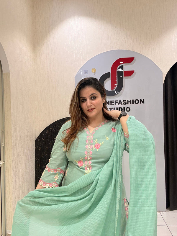 Graceful mint green cotton suit featuring intricate floral embroidery and tassel detailing.