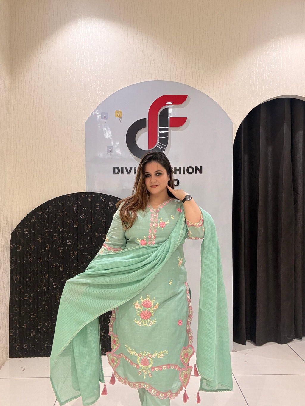 Graceful mint green cotton suit featuring intricate floral embroidery and tassel detailing.