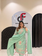 Graceful mint green cotton suit featuring intricate floral embroidery and tassel detailing.