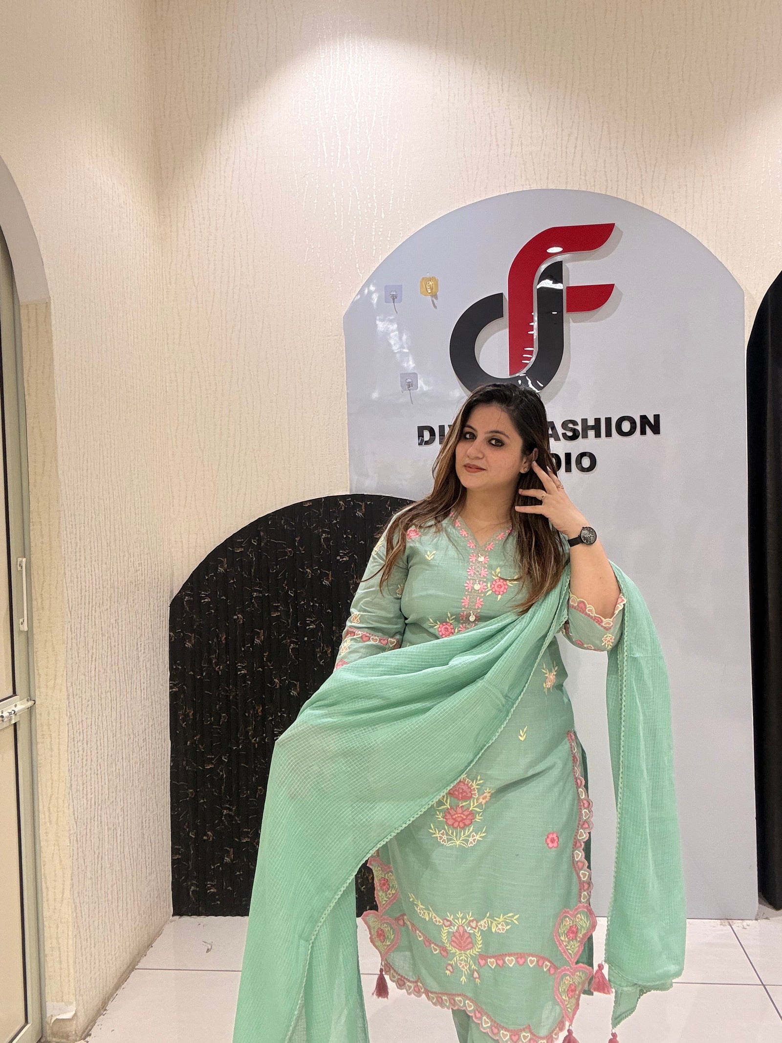 Graceful mint green cotton suit featuring intricate floral embroidery and tassel detailing