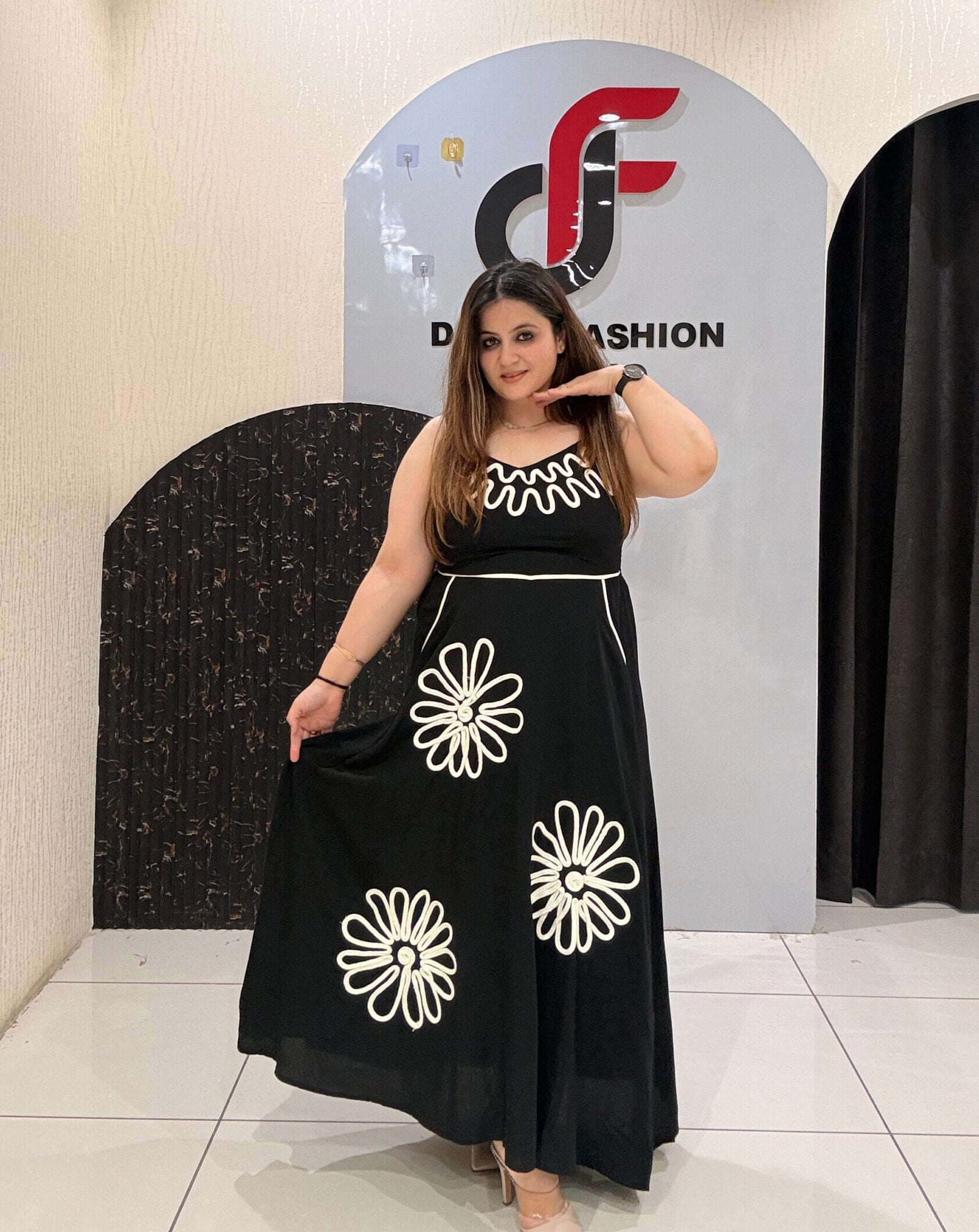 Stylish cotton middi dress featuring bold floral embroidery and a wavy neckline design.
