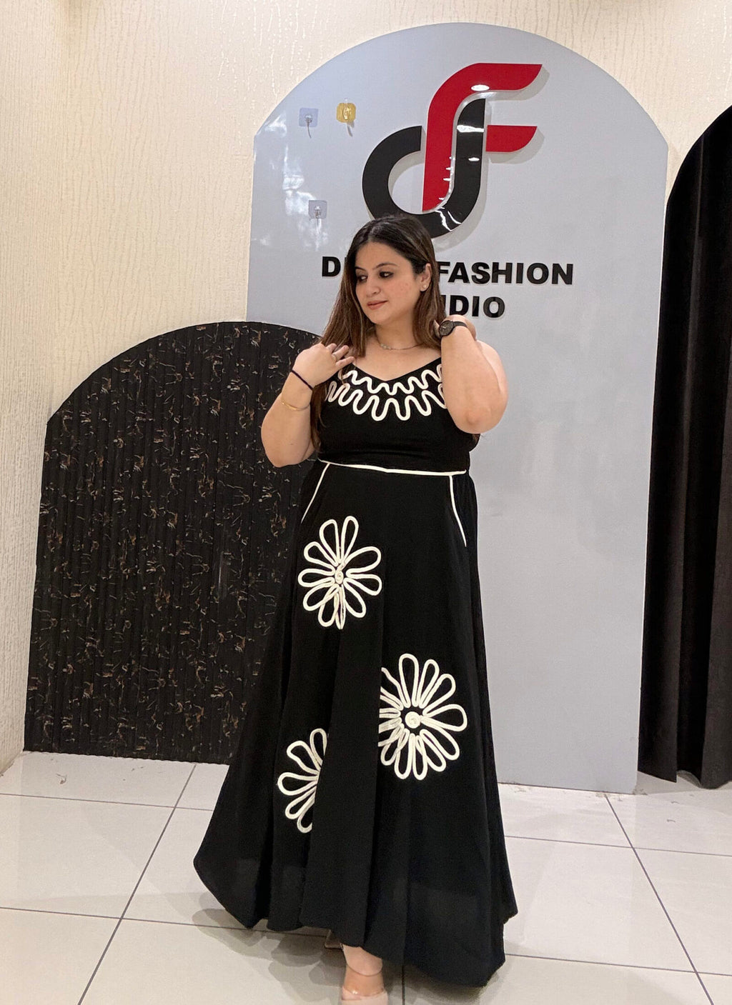 Stylish cotton middi dress featuring bold floral embroidery and a wavy neckline design.
