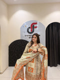 Graceful cream and orange partywear suit featuring intricate ethnic prints and a matching dupatta with tassel detailing.