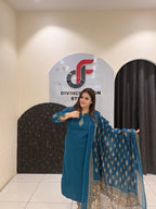 Elegant teal cotton suit featuring a delicate embroidered motif and a matching Kota Doria dupatta with golden patterns.