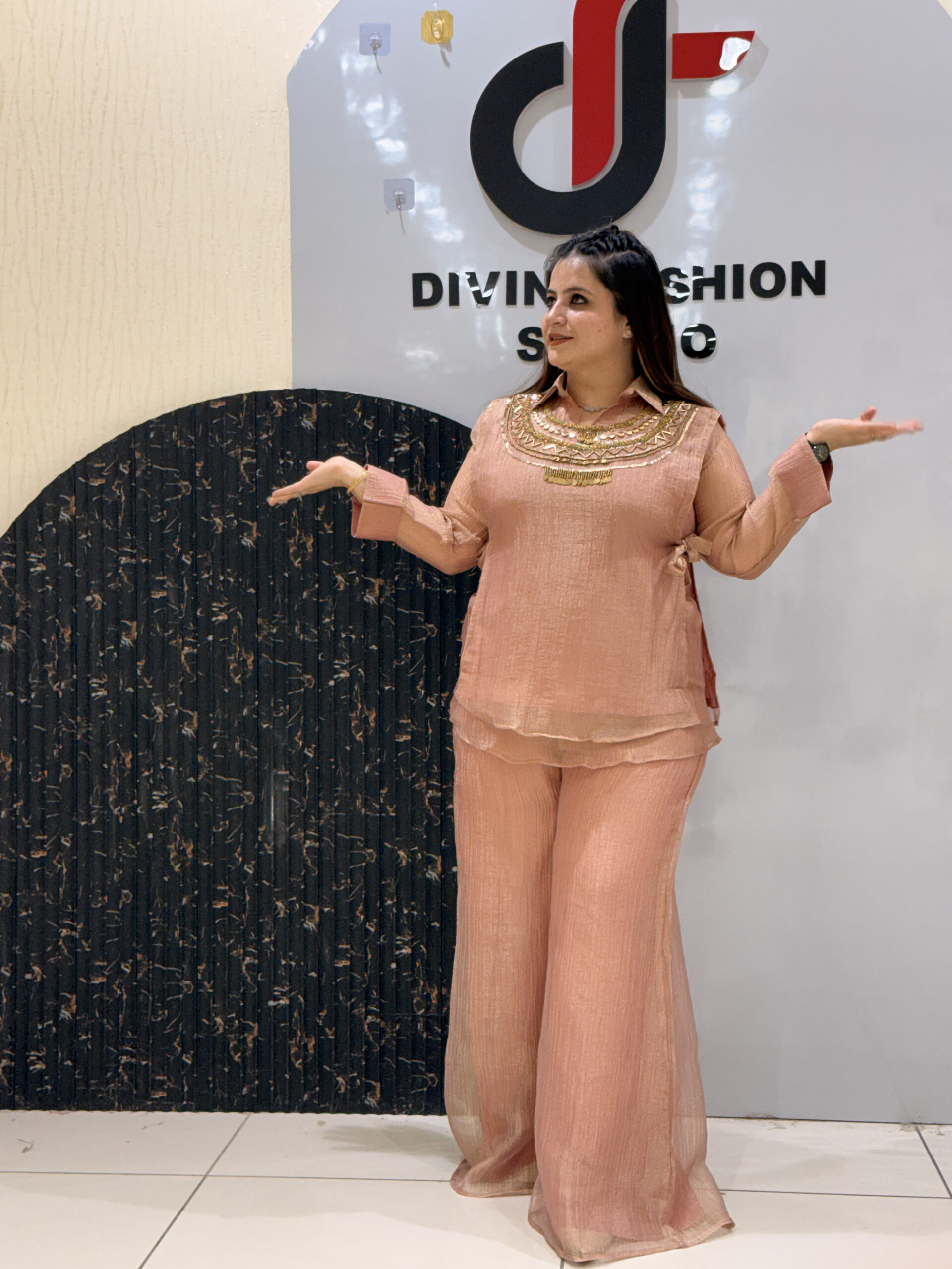 Woman in peach floral embroidered co-ord set gesturing
