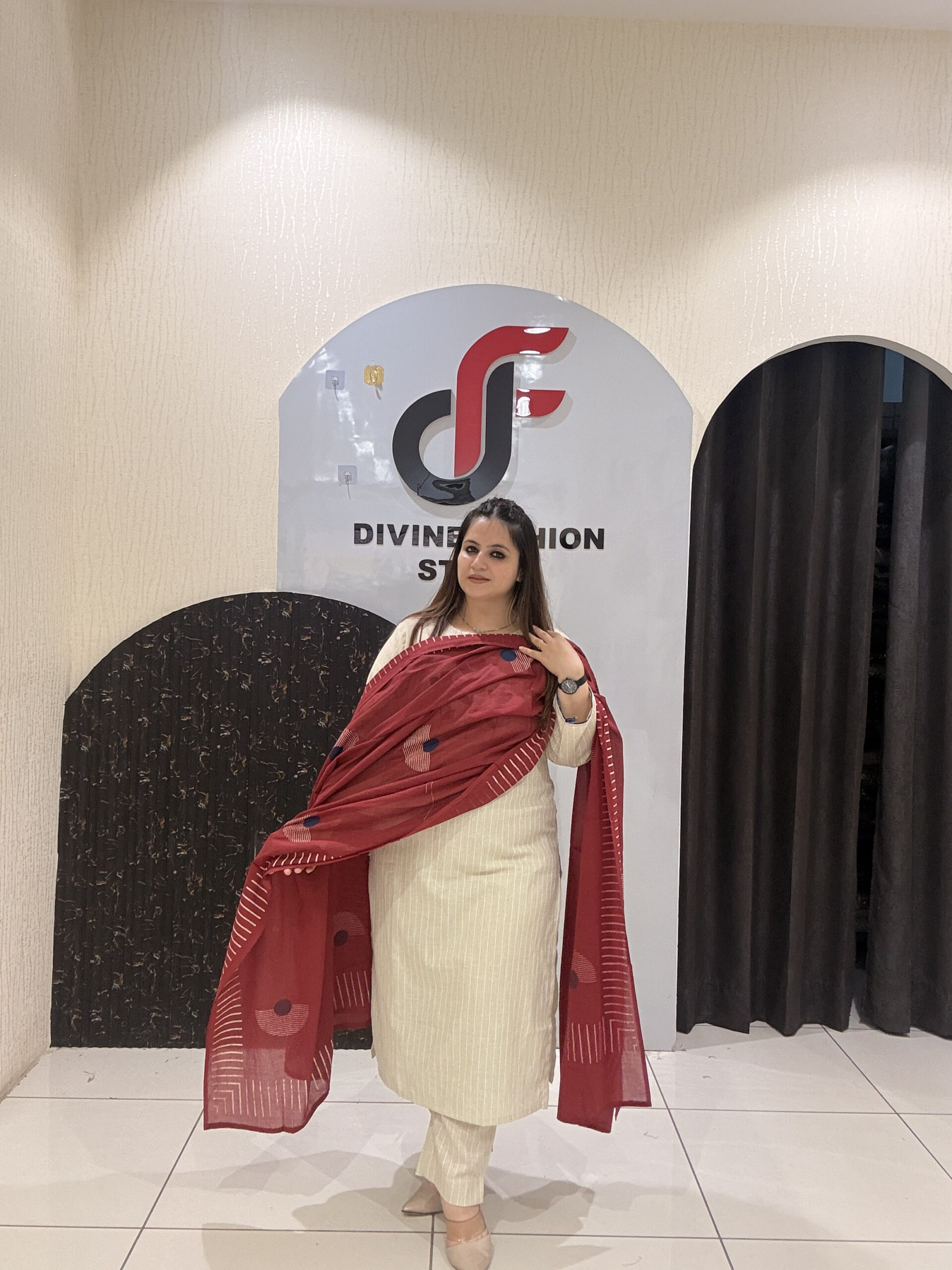 Elegant cream cotton suit featuring floral embroidery in red and blue tones, paired with a contrasting red dupatta.