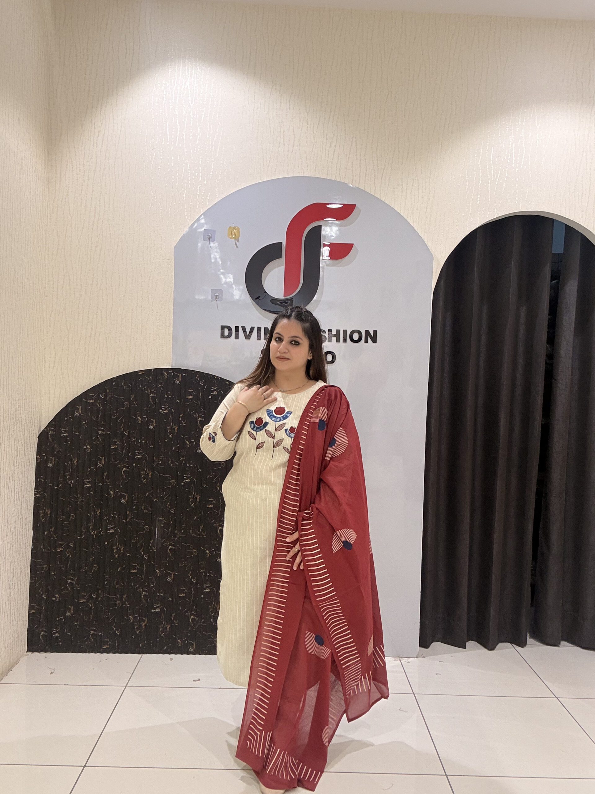 Elegant cream cotton suit featuring floral embroidery in red and blue tones, paired with a contrasting red dupatta.
