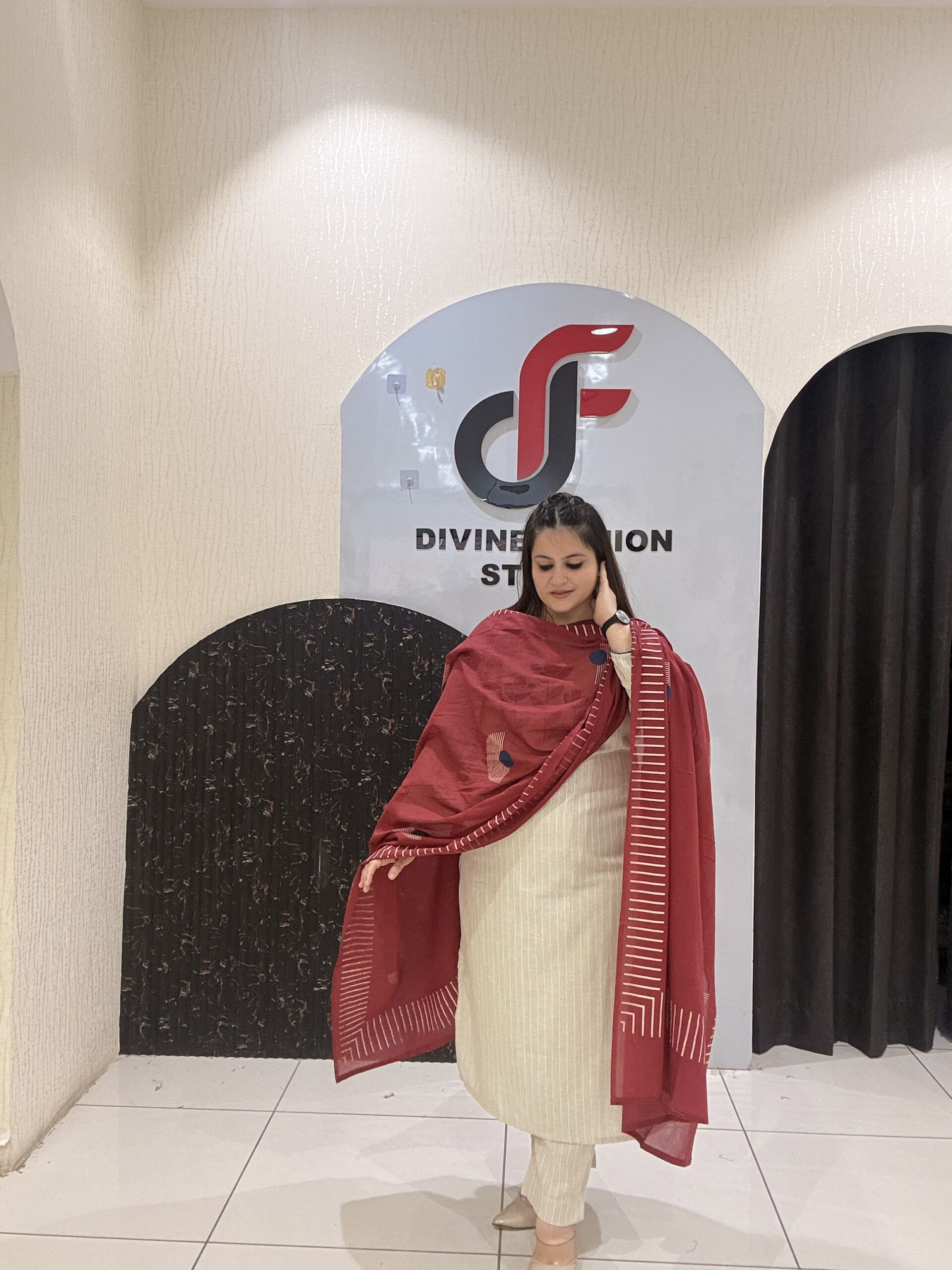 Elegant cream cotton suit featuring floral embroidery in red and blue tones, paired with a contrasting red dupatta.