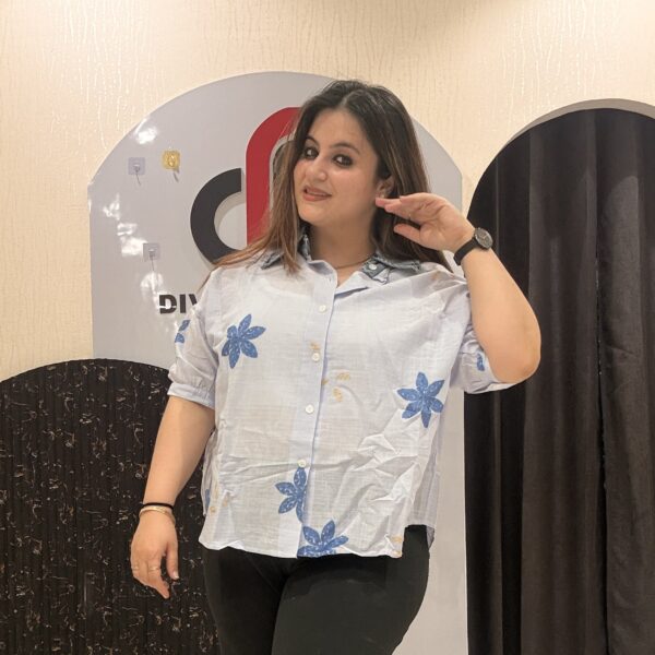 Trendy light blue cotton top featuring bold blue floral embroidery