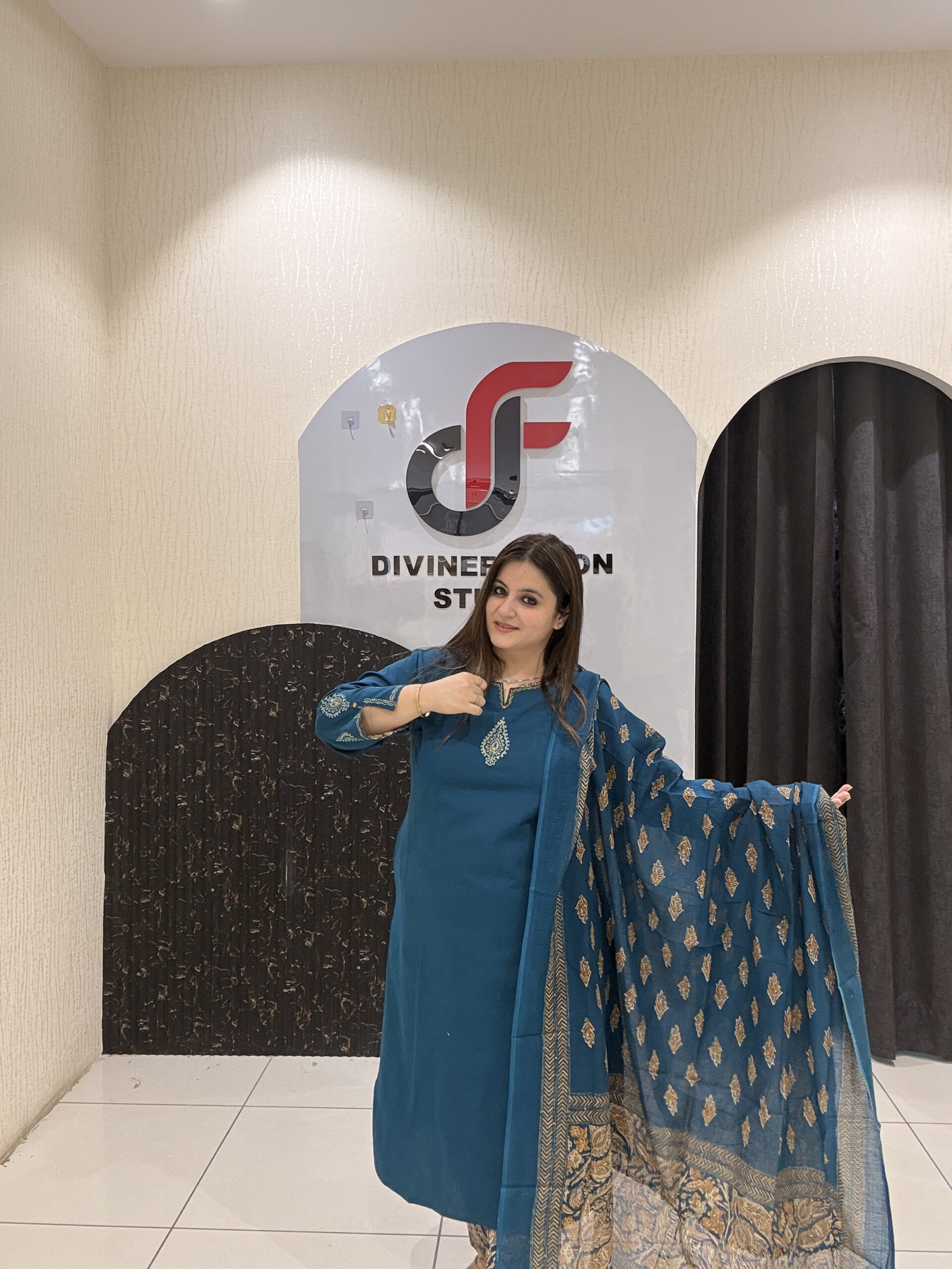 Elegant teal cotton suit featuring a delicate embroidered motif and a matching Kota Doria dupatta with golden patterns.